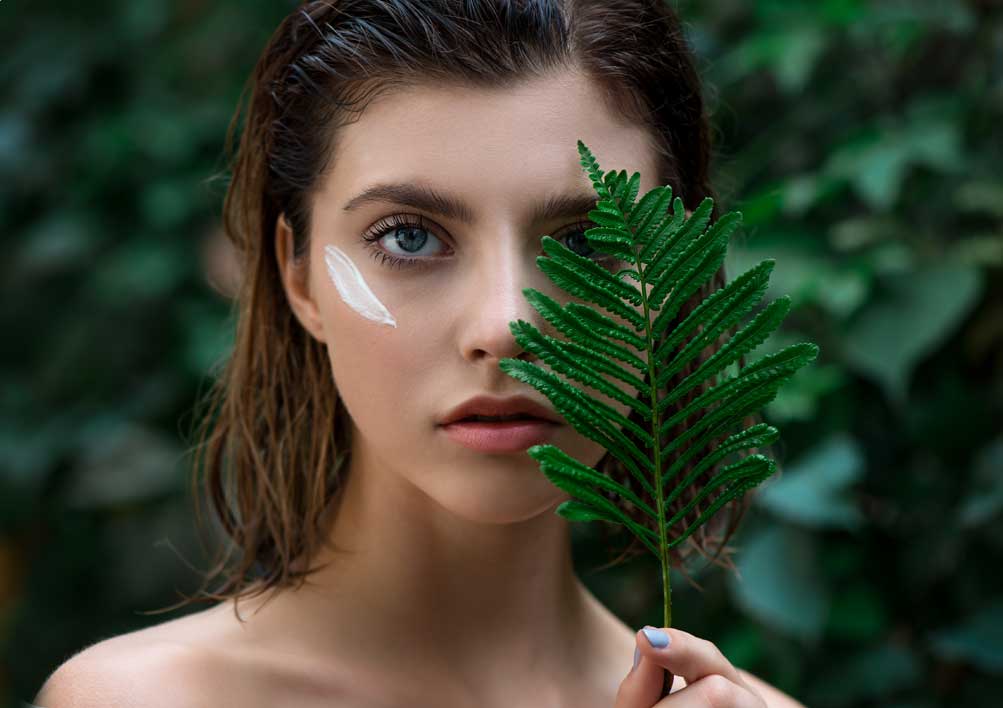 Woman holding a fern leaf